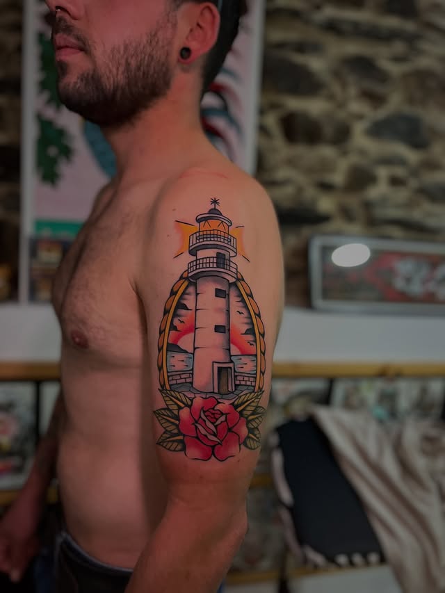 tatuaje faro con rosa estilo tradicional en brazo