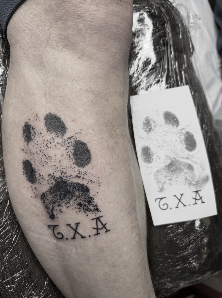 tatuaje huella de perro en pierna con iniciales